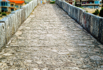 Fototapeta premium Old pedestrian path over stone made medieval bridge in city of Trebinje, Bosnia and Herzegovina.