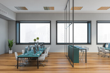 Grey open space office with blue tables, side view