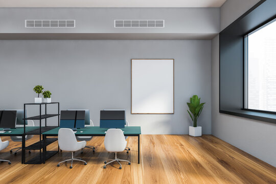 Grey open space office with blue tables, poster