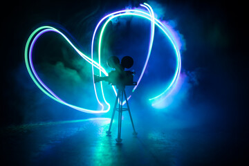Movie concept. Miniature movie set on dark toned background with fog and empty space. Silhouette of...