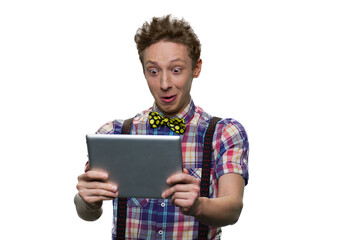 Extremely surprised teenage boy's looking at tablet pc screen. Widely opened eyes. Isolated on white background.