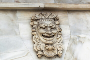 Bas relief decorative mask sculpture on the walls of famous Comedia movie theatre in Barcelona, Spain.