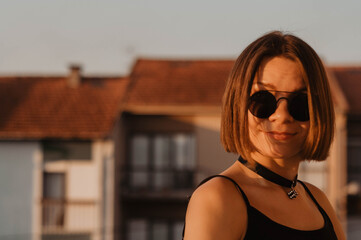 Beautiful brunette girl having glasses sun protective, smiles. Portrait. Blurred background.  Model