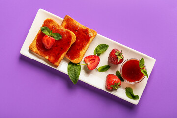 Plate with tasty strawberry jam and bread on color background