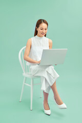Beautiful student sitting in a chair with a laptop