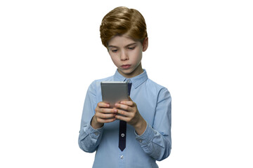 Boy in blue t-shirt enthusiastically looking at his smartphone. Teenager holding mobile phone with both hands isolated on white.