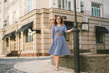 Naklejka premium Caucasian woman in dress travels in old European town. Trip and rent, book hotel for weekend, rent apartments in city center. Llifestyle summer vacations. Discovery of unknown corners of the world