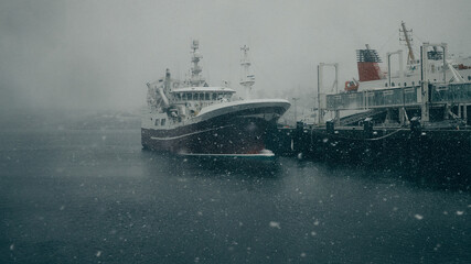 ship in the harbor while it snows