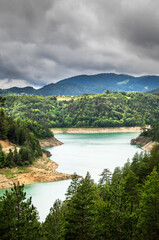 Fototapeta na wymiar Beautiful Zaovine lake surrounded with forest on Tara mountain in Serbia. Cloudy and foggy day.