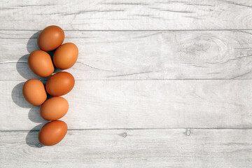 Eggs on a table top. Flat lay with rustic table background and copy space. 