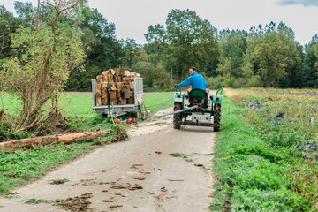 Man pulling tree trunk with tractor