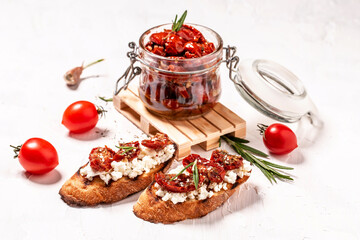 Vegetarian breakfast of champions. Sandwich with sun dried tomatoes and ricotta diet cheese on toasted bread. Delicious breakfast or snack on a light background
