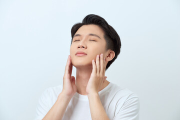 Handsome man touching his face close up portrait studio on white background