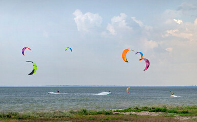 People engaged in kitesurfing and windsurfing