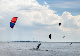 People engaged in kitesurfing and windsurfing