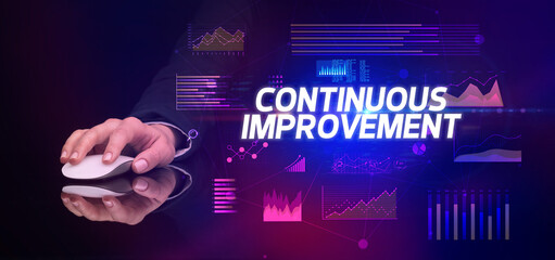 hand holding wireless peripheral with CONTINUOUS IMPROVEMENT inscription, cyber business concept