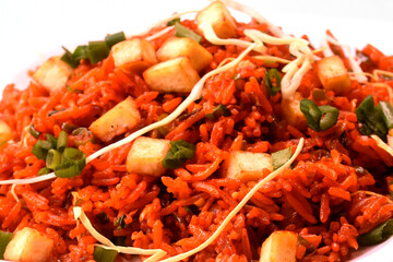 Schezwan paneer fried rice with schezwan sauce,Chinese fried rice with paneer,garnished with spring onion and cabbage