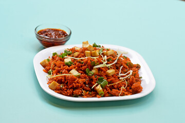 Schezwan paneer fried rice with schezwan sauce,Chinese fried rice with paneer,garnished with spring onion and cabbage