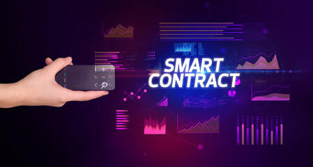 hand holding wireless peripheral with SMART CONTRACT inscription, cyber business concept