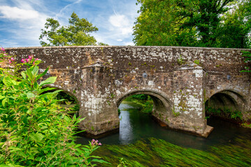 Fototapeta na wymiar Woolbeding Bridge a medieval bridge over the River Rother in the South Downs National Park, near Midhurst West Sussex. Restored in 1919, there are less than 200 multispan medieval bridges in England.