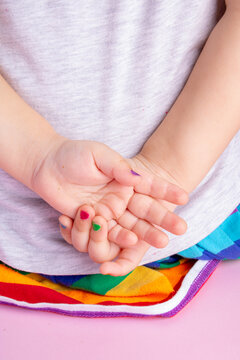 little girl hands with colorful manicure behind back, vertical image