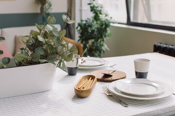 Elegant crockery and decor on table in modern dining room. Table set for family dinner.
