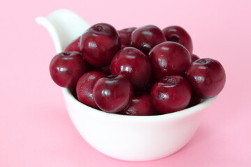 bowl of cherries close up macro on pick bckground 
