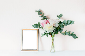 Mock up of the frame with a bouquet of peonies and eucalyptus branches