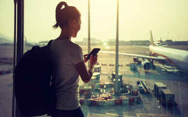 Woman passenger using mobile phone in airport