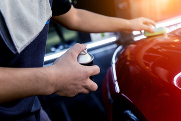 Car service worker applying nano coating on a car detail