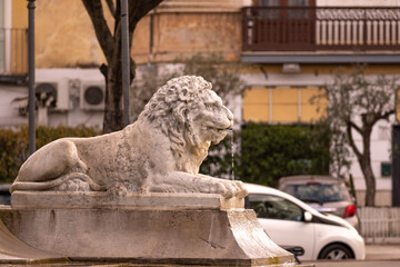 Statue of a lion in a fountain, white stone lion