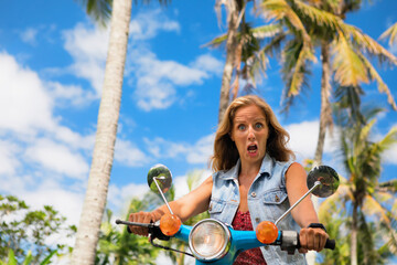 Face portrait of young woman cry frightened. Girl riding on rental motorbike without helmet . Risk...