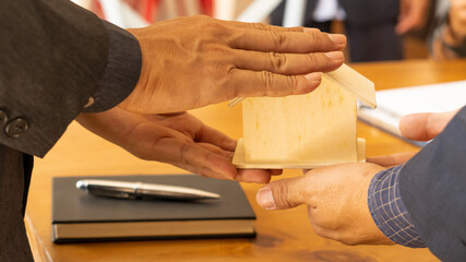 Obraz premium BusineEstate representatives are giving the house to customers after the contract behind the house architecture.