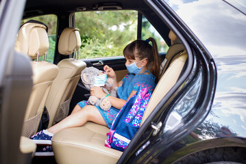 Cute girl playing in  car  teddy bear in medical masks