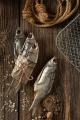 Sun dried fish, salted smelts over wooden background. Snack for beer dried smelts.