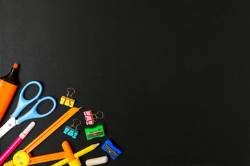 School supplies on a black school board. back to school. primary or elementary education concept. Stationery shop concept. Copy space, flat lay, top view.