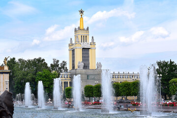 Moscow, Russia - July 2, 2020: Grain pavilion in VDNKH park on a sunny day. Fountain jets in the...