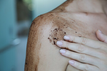 Fototapeta premium DIY Coffee scrub. Beauty skin care. Young woman putting coffee scrub on her neck and shoulders. 