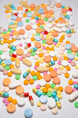 Colorful drugs, vitamins and medicine - capsules, tablets, pills - against white background