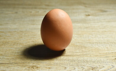  brown egg shell with shadow on wooden table background