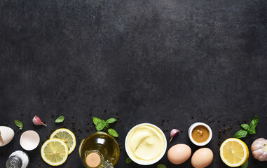 Homemade mayonnaise on a black background. Ingredients for making the sauce: egg, butter, mustard.