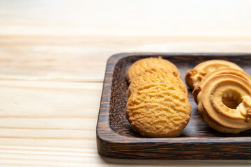 Fototapeta na wymiar Cookies in a wooden plate on wooden table