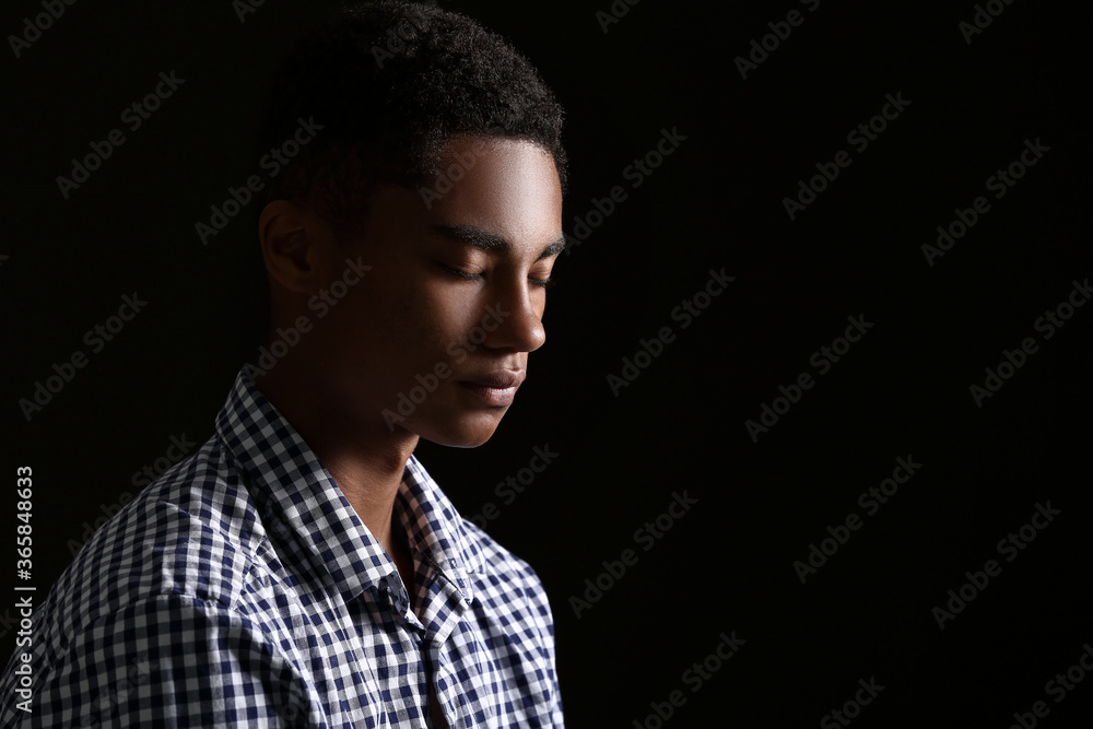 Wall mural sad african-american teenage boy on dark background. stop racism