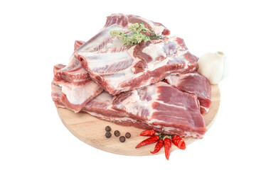 Raw pork ribs and condiments laid out on a wooden cutting board. Raw pork ribs, pepper, basil and condiments