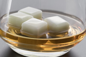 The glass of whiskey with stones cubes