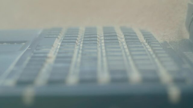 Protective, resistant, safety, technology concept. Keyboard of dustproof rugged laptop computer for military, outdoor and industrial use during dust resistance test - sand storm - close up view