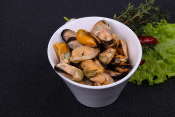 Pickled mussels in the bowl served pepper, garlic and salad