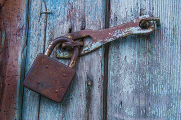 Rusty padlock on wooden door
