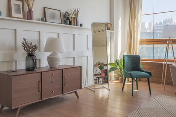 Vintage studio apartment interior in light colors in old style. huge room with large windows with a living room area and a bedroom area. direct sunlight inside.