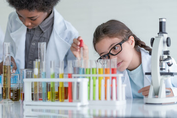 Little girl scientist making experiments chemical in glass tube in the laboratory room